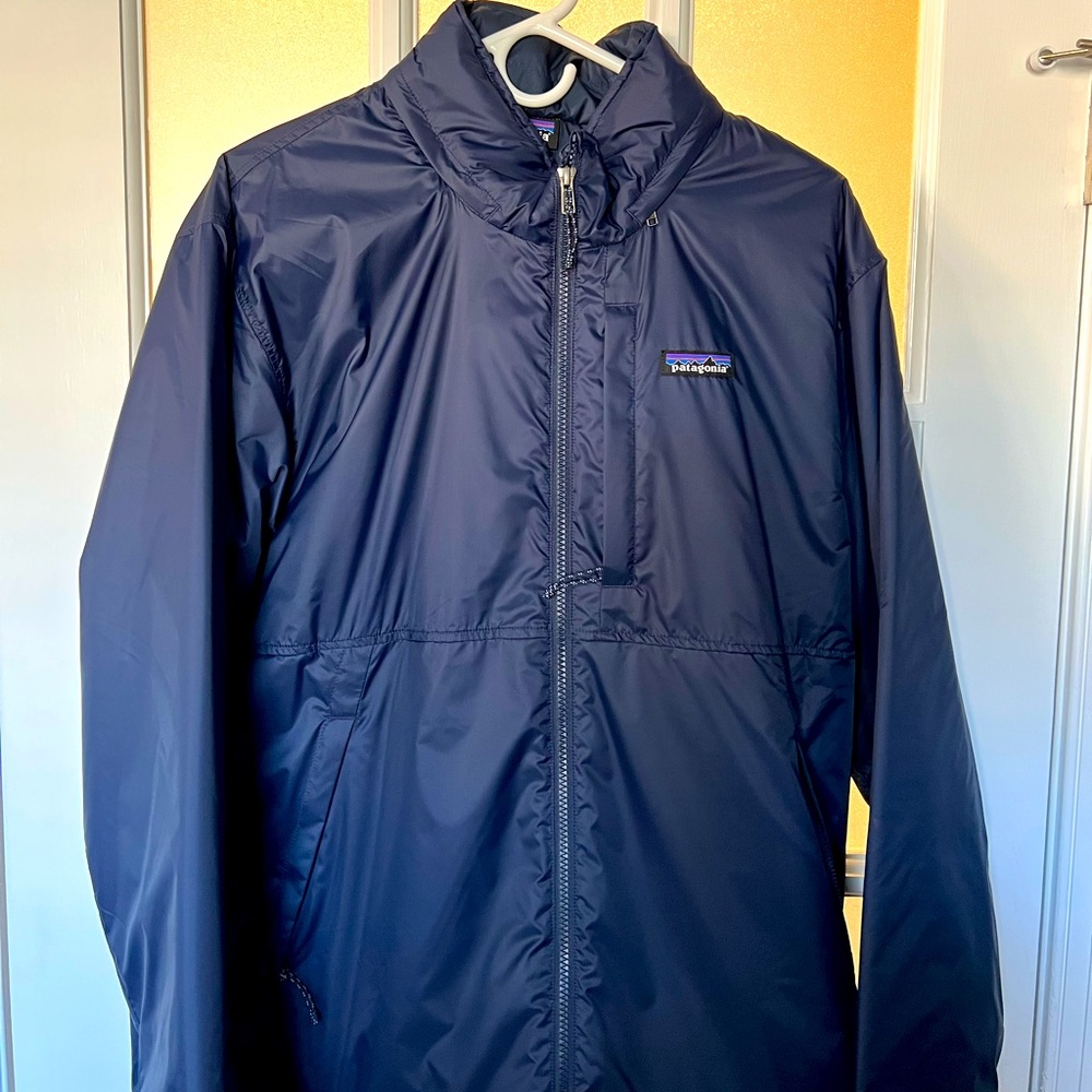 Like new Patagonia light jacket with stowable hood. Beautiful navy blue color.